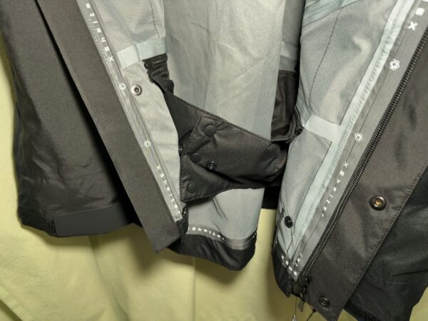 エックスシェルター(R)プレミアム超透放湿ウルトラレインジャケット腰内側ウィンドガード締めた画像